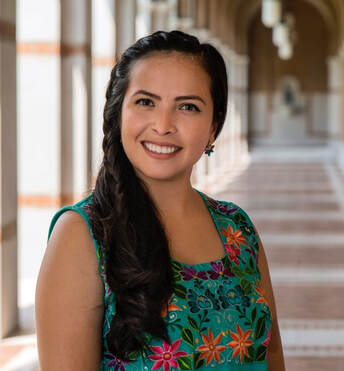 Dr. Michelle Torres in a floral dress, long dark hair, smiling.